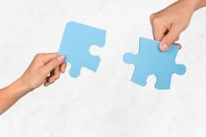 青いパズルを持つ女性の手